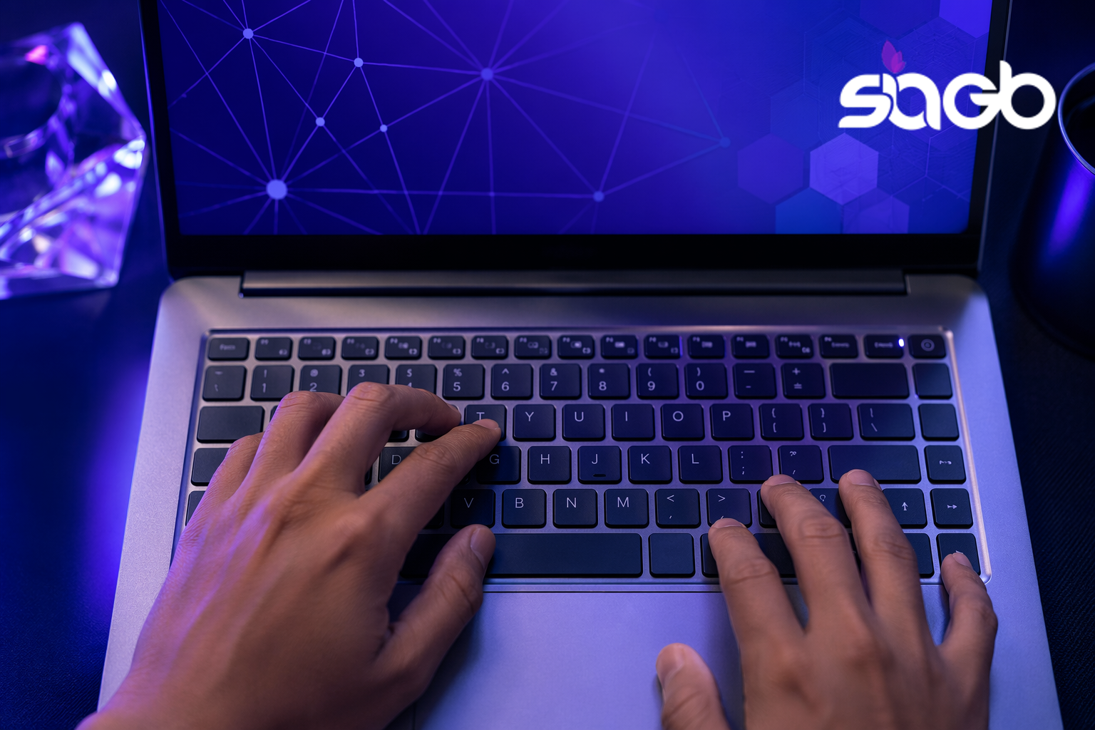 Hands typing on a laptop displaying a purple network graphic, illustrating healthcare SEO and intent based search for clinics